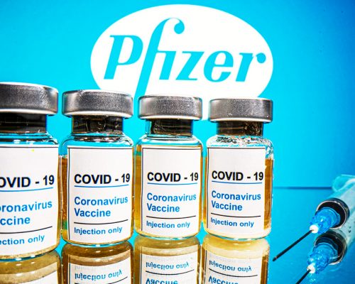 FILE PHOTO: Vials with a sticker reading, "COVID-19 / Coronavirus vaccine / Injection only" and a medical syringe are seen in front of a displayed Pfizer logo in this illustration taken October 31, 2020. REUTERS/Dado Ruvic/Illustration/File Photo